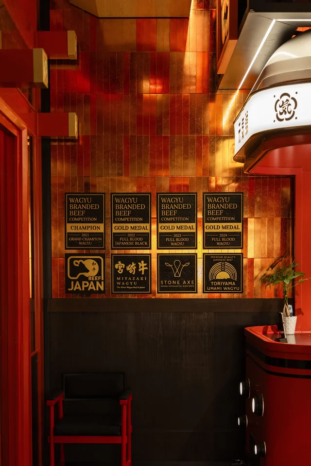 Warm gold walls and framed plaques beside the red welcome desk